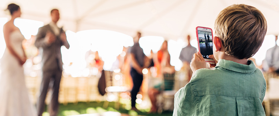 Child takes photo of bride and groom